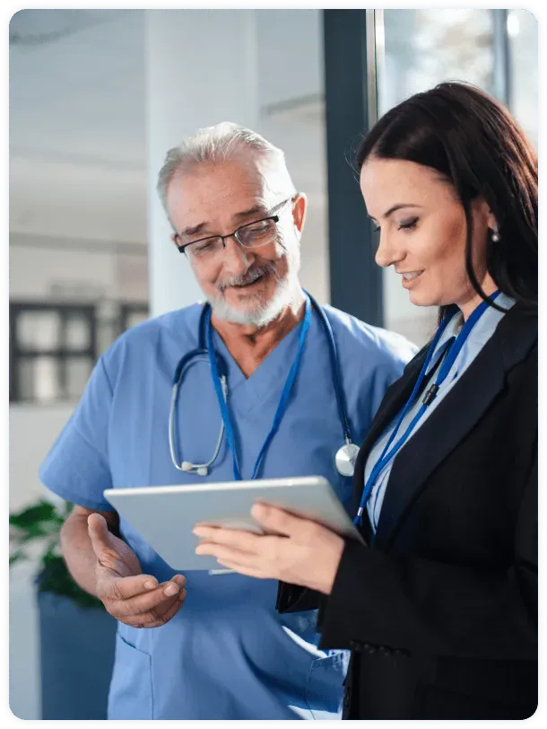 A dentist and a healthcare practice owner reviewing notes together